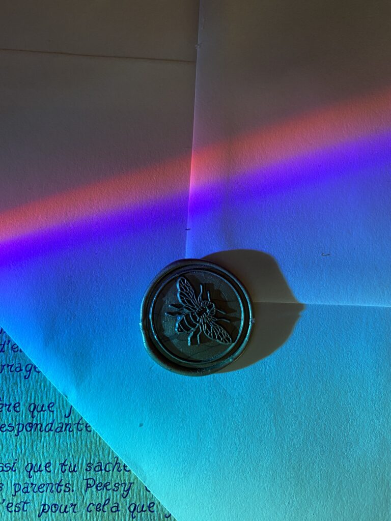 Photo d’un sceau de cire doré représentant un scarabée, symbole d’Athéna – Minocha Letters